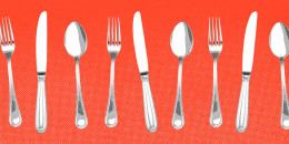 Forks, knives, and spoons lined up against a red background.